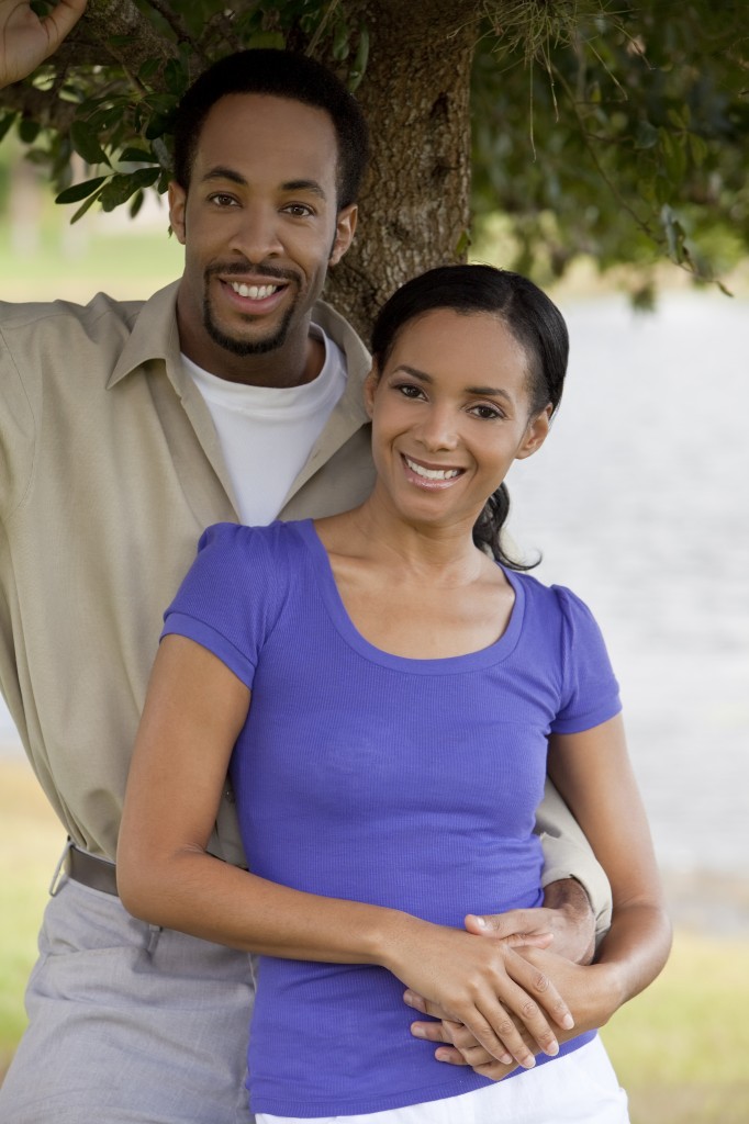 Happy African American Couple Holding Hands Under A Tree